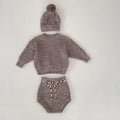Dark brown knitted baby girl three-piece set with removable fur ball hat, blouse, and shorts