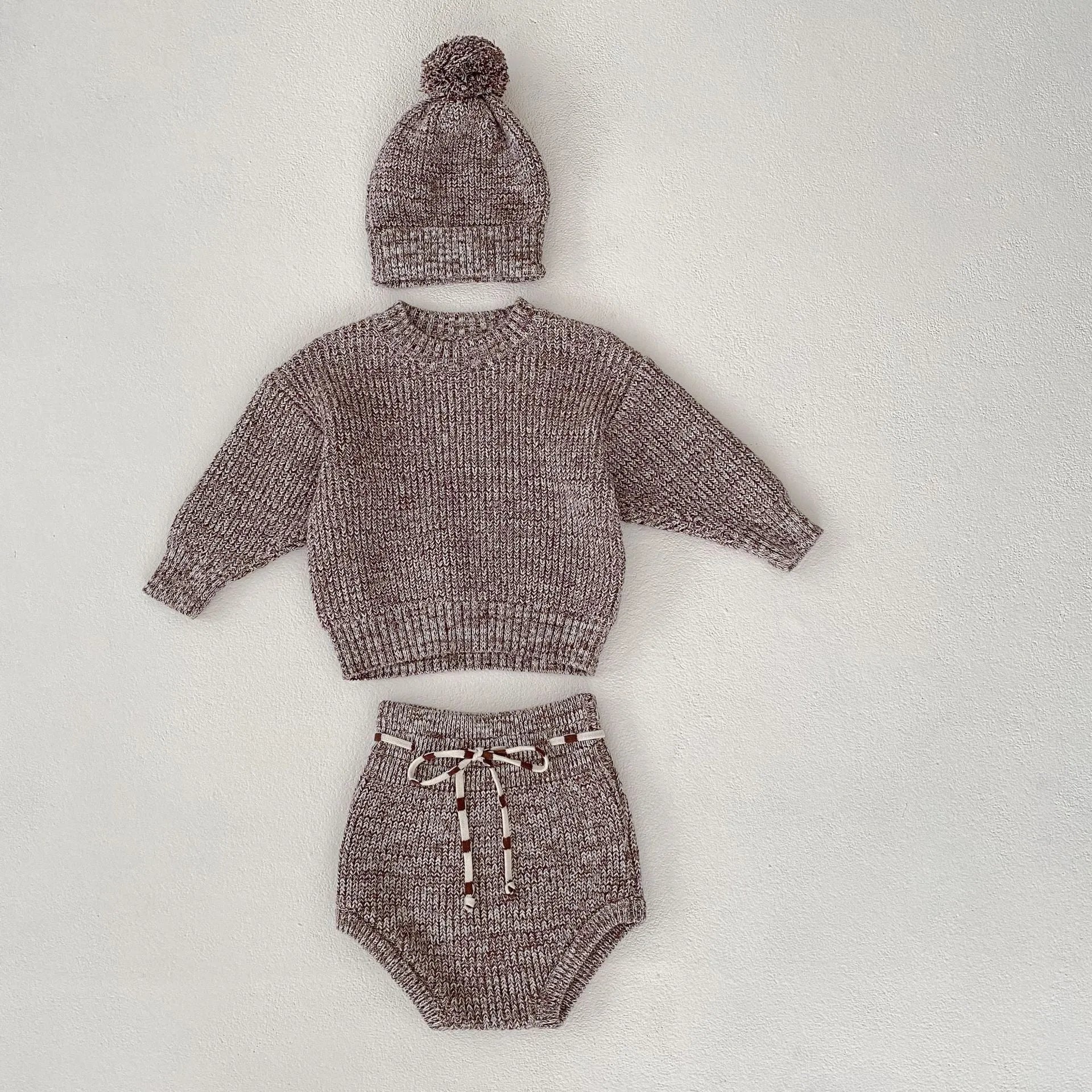 Dark brown knitted baby girl three-piece set with removable fur ball hat, blouse, and shorts