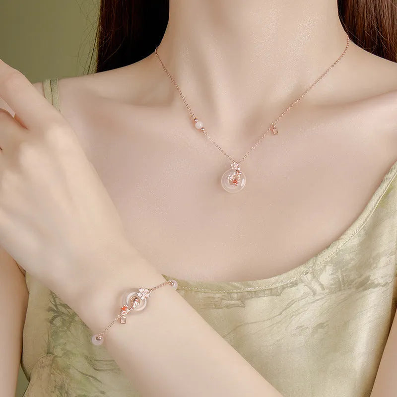 Close-up of a sterling silver bracelet with white chalcedony stones in a koi design on a wrist.