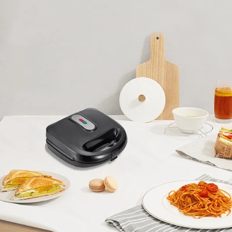 Black double-sided electric sandwich pan with brushed stainless steel lid and six removable non-stick plates.