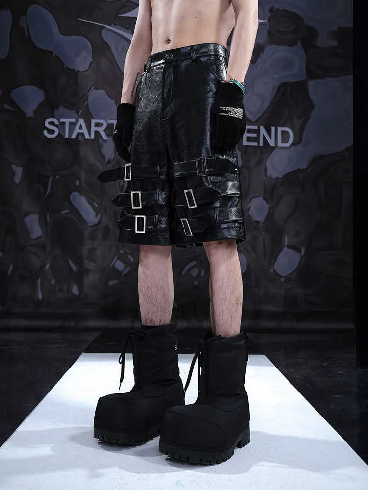 Men's black casual cropped shorts with a prominent leather ring detail on the front.