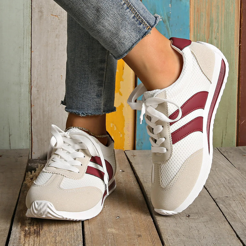 Wine red casual sneakers with cross straps over a breathable mesh and synthetic leather upper.