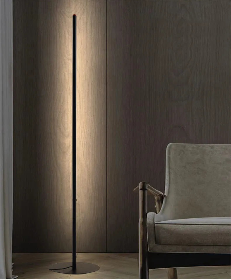 Tall, slim aluminium alloy vertical LED floor lamp standing beside a modern sofa.