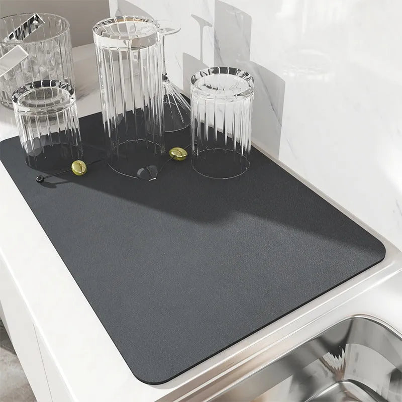 Square super absorbent drain mat with rubber backing in black or blue on a kitchen counter.