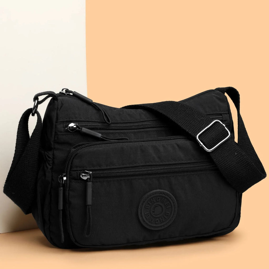 Water-repellent nylon crossbody bag with three-dimensional pocket in black, grey or red