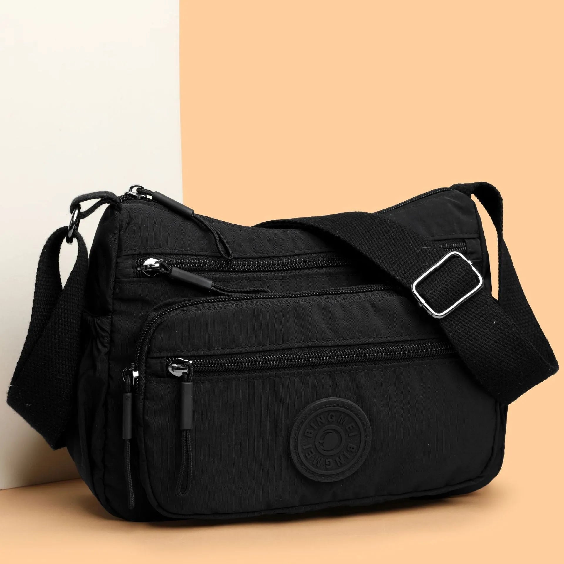 Water-repellent nylon crossbody bag with three-dimensional pocket in black, grey or red