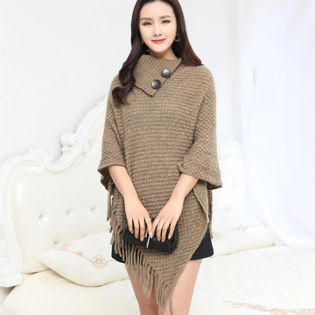 Dotted pattern sleeveless knitted cloak shawl in acrylic fibre, shown in apricot colour.