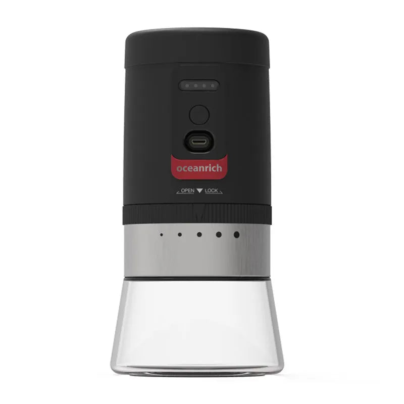 Black portable hand crank coffee grinder with manual grinding mechanism on counter