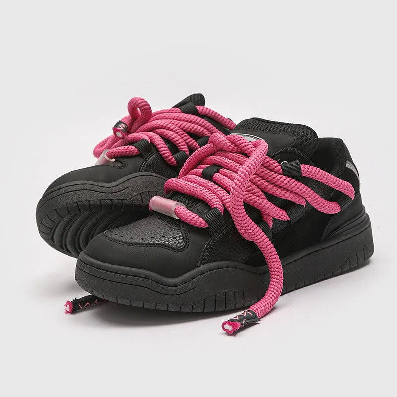 Pair of thick-soled casual lace-up trainers in a solid colour on a white background.