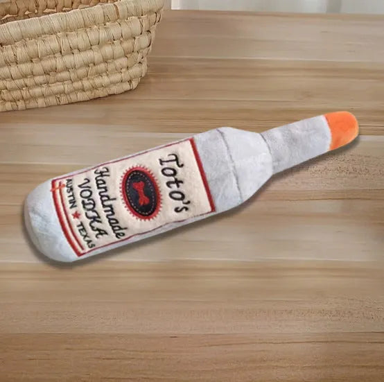 Brown plush dog toy shaped like a wine bottle with textured surfaces and a squeaker.