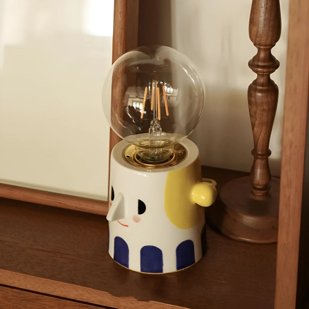 Handmade ceramic table lamp with a spherical white ball headlight shade on a solid base.