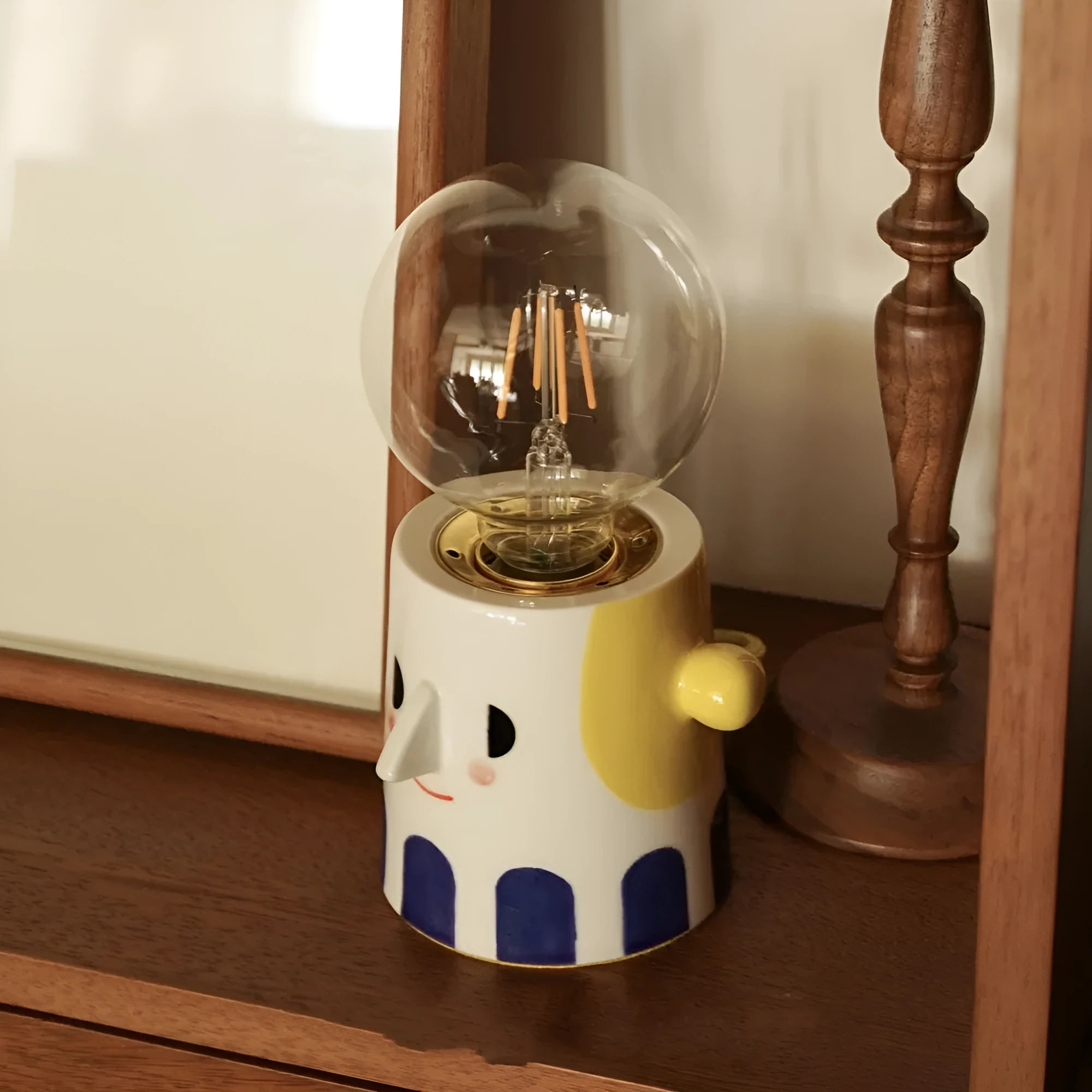 Handmade ceramic table lamp with a spherical white ball headlight shade on a solid base.