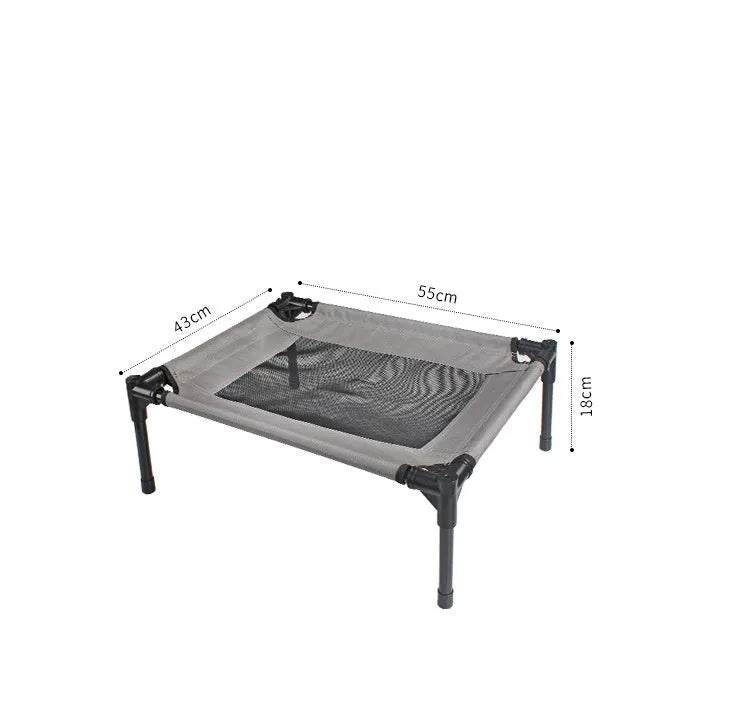 Black Oxford cloth outdoor dog bed with steel frame, shown on grass for camping use.