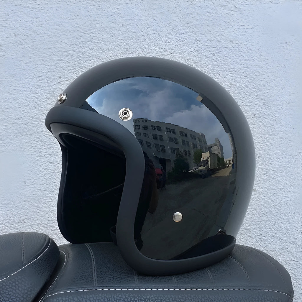 A retro-styled half motorcycle helmet made from glass fibre, shown in a matte black flower colour finish.