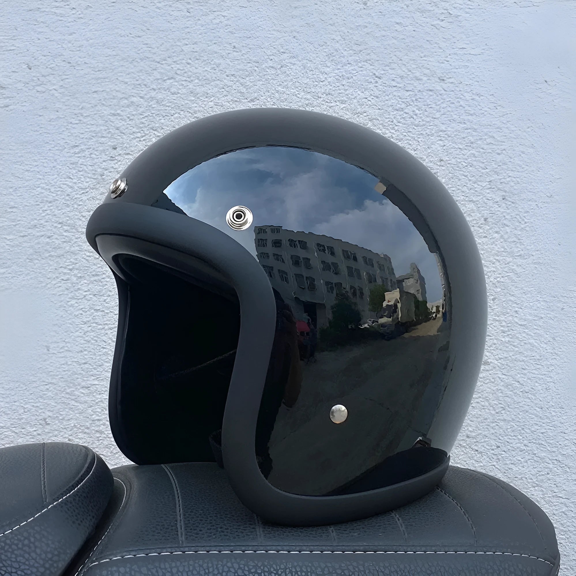 A retro-styled half motorcycle helmet made from glass fibre, shown in a matte black flower colour finish.