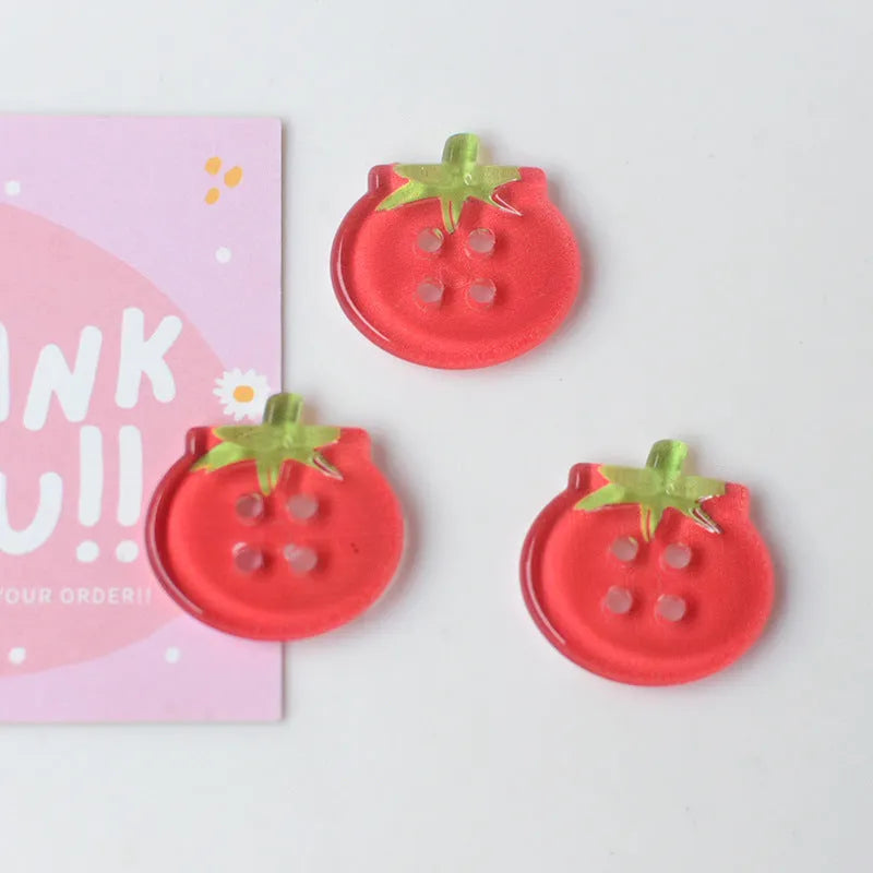 A pack of medium-sized plastic tomato button ornaments in mixed colours including red plaid and cherry tomato print.