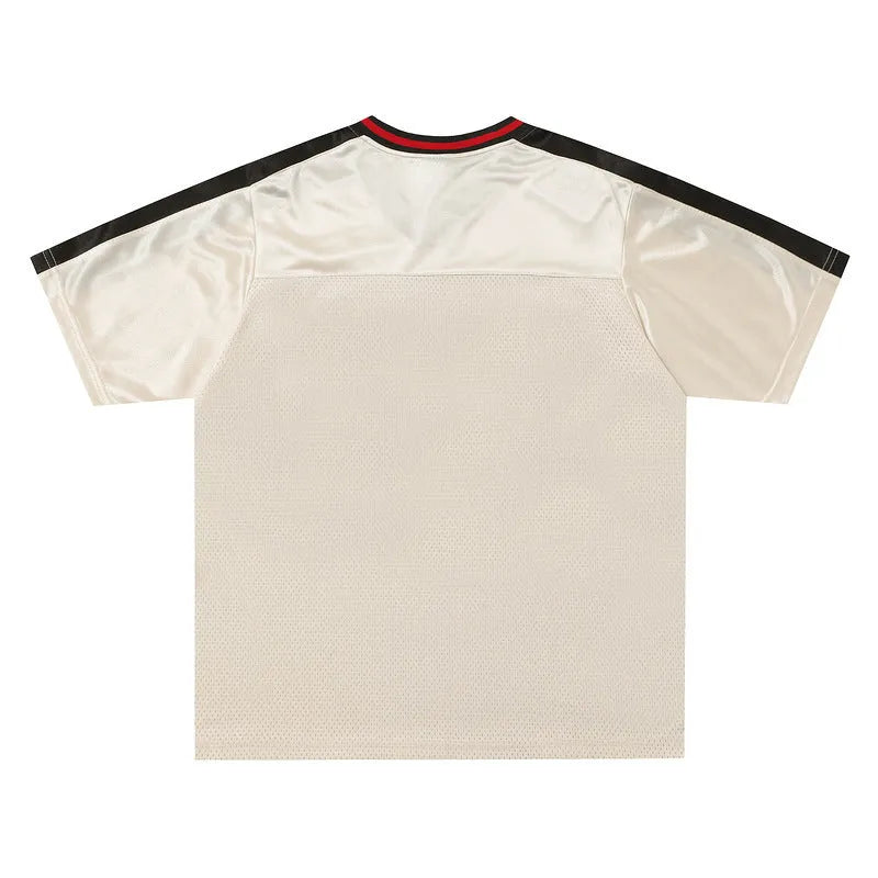 Apricot coloured loose fit sports top with V-neck, short drop-shoulder sleeves, and a letter pattern.