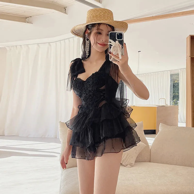 Black one-piece swimsuit with gathered chest detail for conservative coverage, sleeveless design