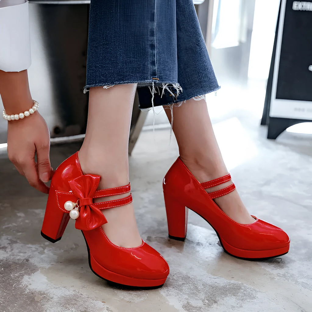 Red women's chunky heel platform shoes with a round toe and buckle fastening on a rubber sole.