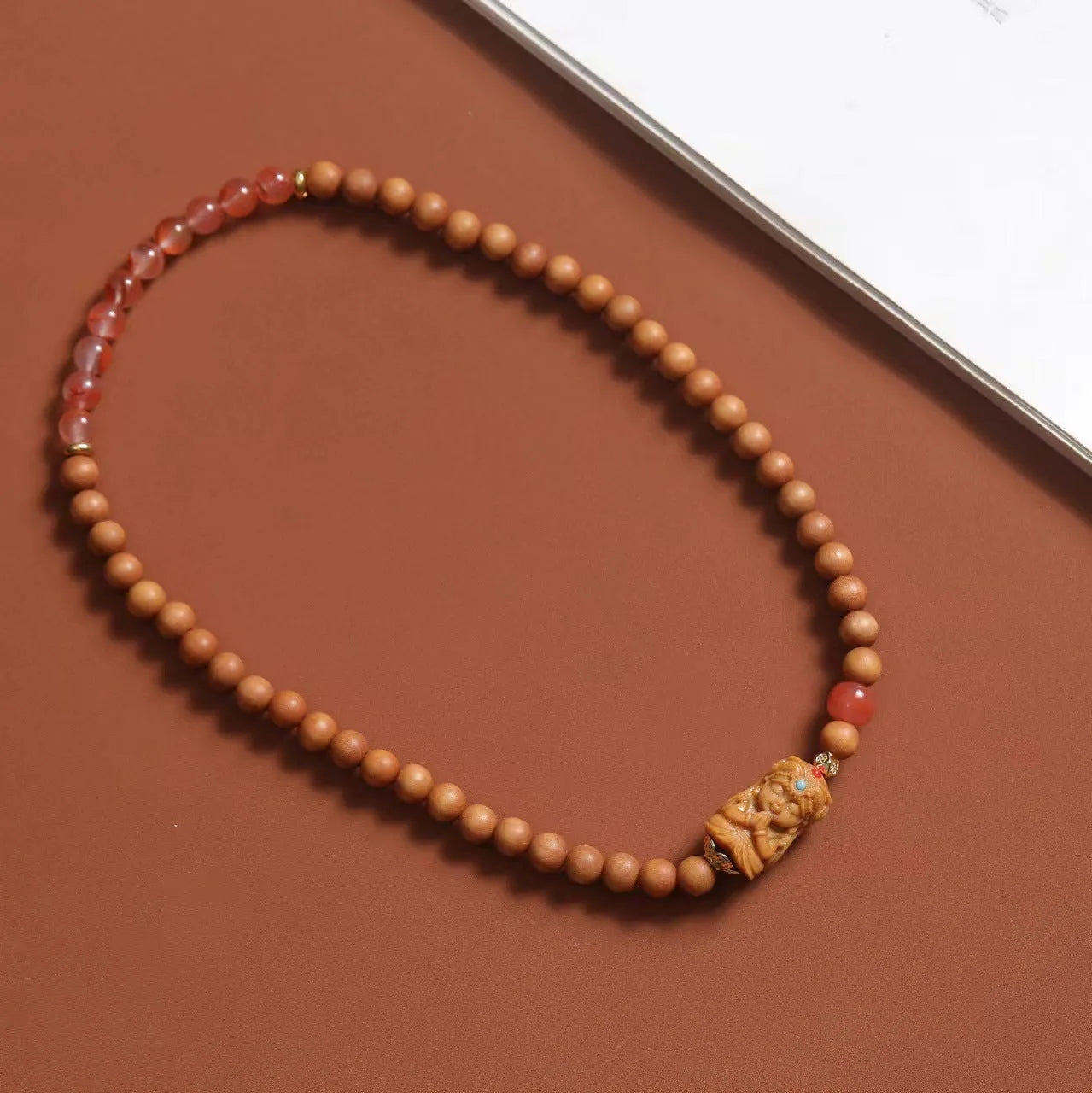Brown wooden bracelet with 6mm round beads featuring a woven South Red Zachilam double circle design.