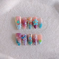 Handmade colourful flower and butterfly sculpture nail art stickers on almond-shaped false nails.