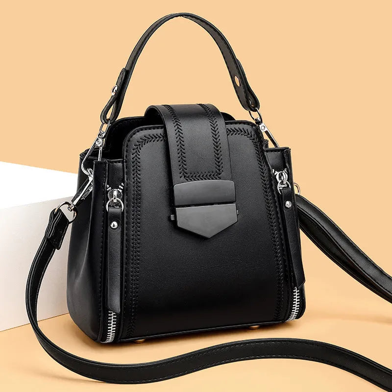 Soft textured PU leather ladies handbag in a square vertical shape with sewn thread detailing.
