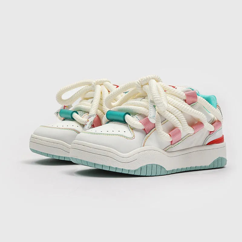 Pair of thick-soled casual lace-up trainers in a solid colour on a white background.