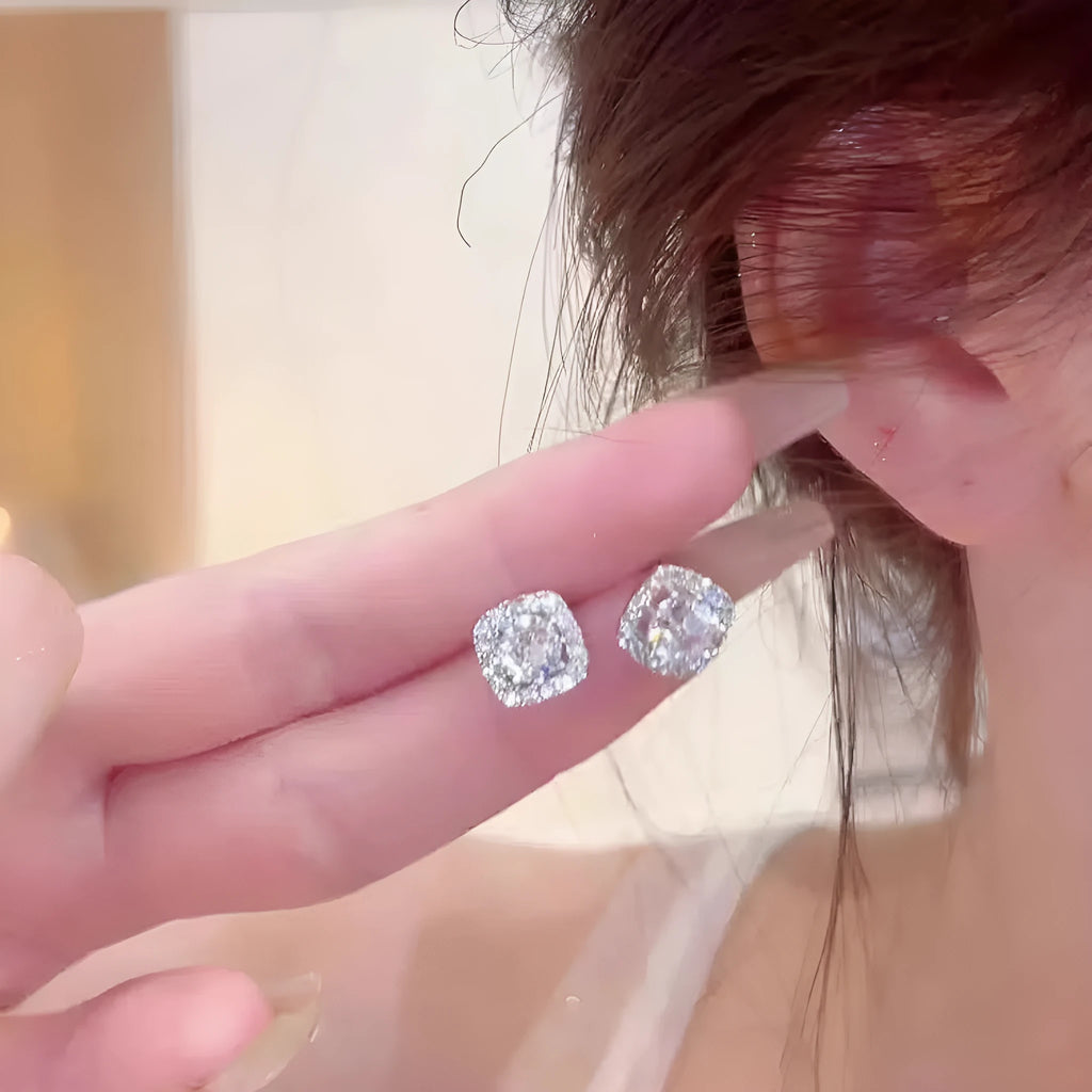 A pair of square-shaped geometric earrings with a diamond treatment detail, shown in a gold colour finish.