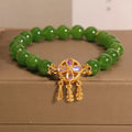 Green jasper crystal four-leaf clover dream catcher pendant bracelet on a natural cotton cord.