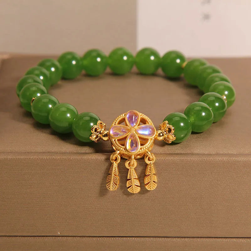 Green jasper crystal four-leaf clover dream catcher pendant bracelet on a natural cotton cord.