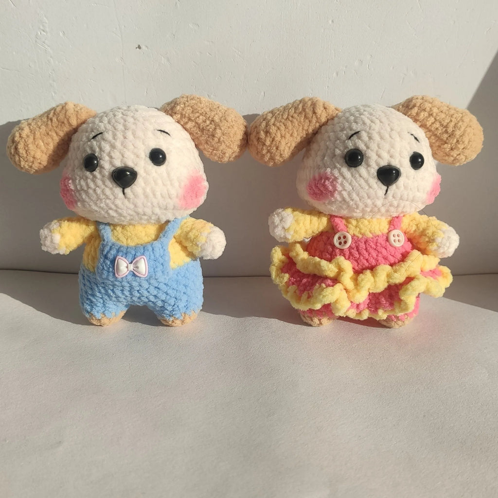 A pair of wool zodiac dog pendant charms on keychains, one wearing a strap skirt and the other strap pants.