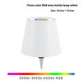 Plug-in wine bottle lamp with RGB tricolour dimming in wrought iron black finish on a table