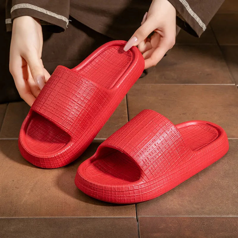Women's soft EVA non-slip bath slipper in black, showing toe ring flip-flop design and textured sole.