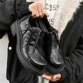 Black platform shoes with round toe and low top design for height enhancement