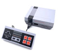 Compact red and grey retro NES game console with two wired controllers on a wooden table.