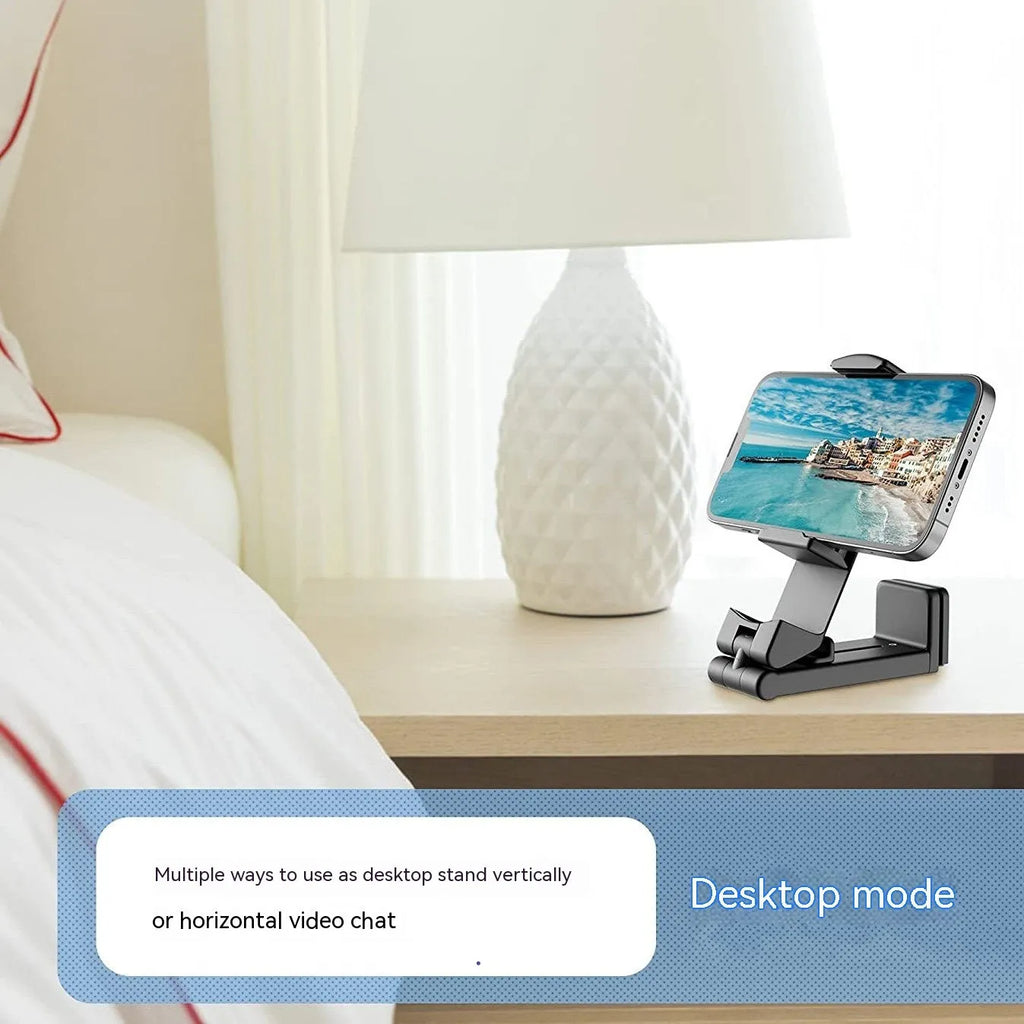 Black foldable and rotating universal mobile phone holder made from ABS plastic on a flat surface.