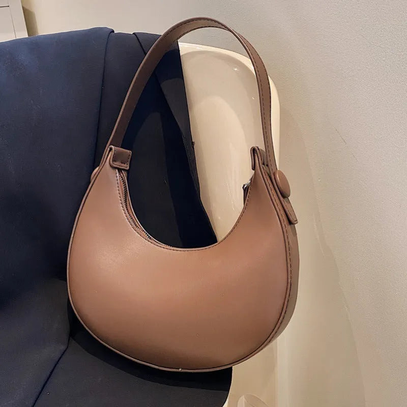 Retro dumpling-shaped women's shoulder bag in PU leather with a front pocket.