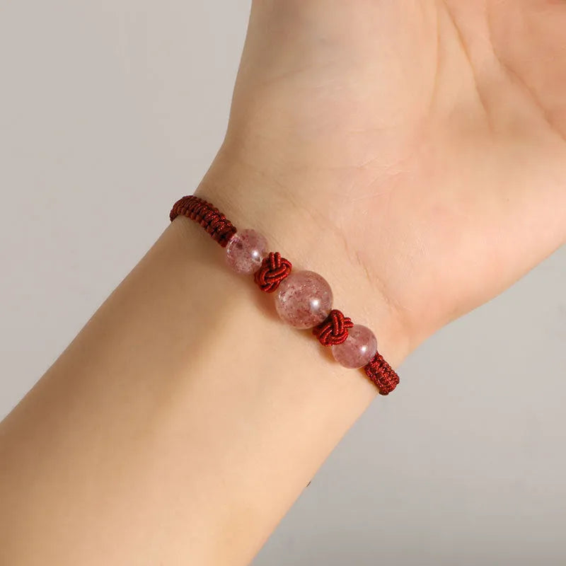 Woven red rope bracelet with spherical strawberry quartz beads and alloy clasp