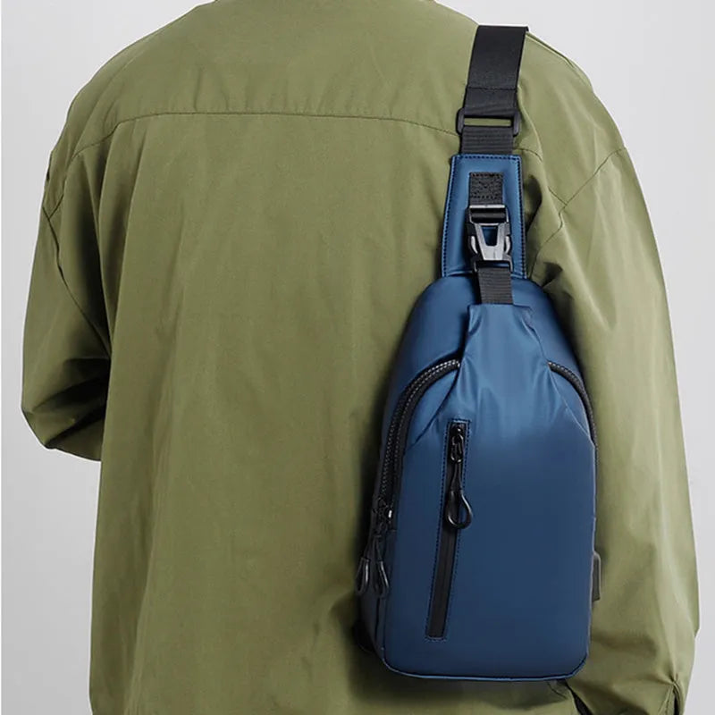 Black sling crossbody chest bag for men with zipper closure and stitched detail on a white background