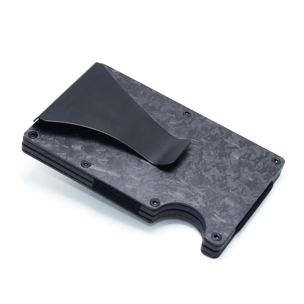 Slim black carbon fibre card holder wallet with geometric design on a desk.