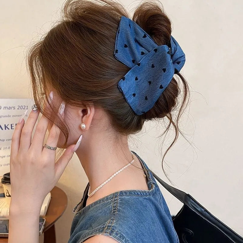 Handmade triangle-shaped hair clip for women in fabric and acrylic, showing plastic grip.