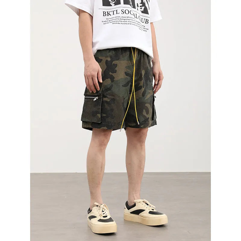 Men's camouflage-coloured cropped shorts with multiple three-dimensional cargo pockets on the legs.