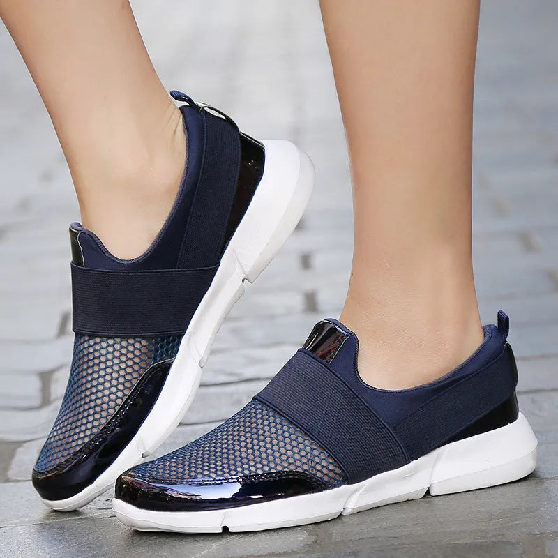 Low-cut blue, black, and grey women's sneakers with a mesh interior on a plain background.
