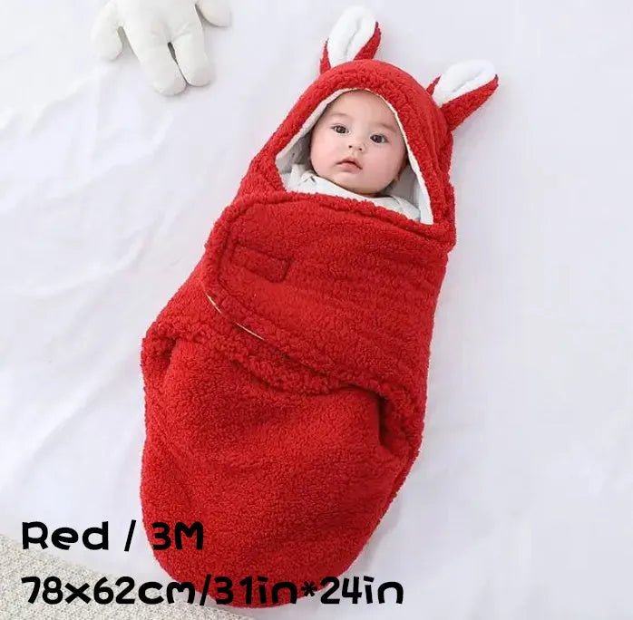 A baby wearing a soft grey fleece sleeping bag with hook-and-loop shoulder straps.