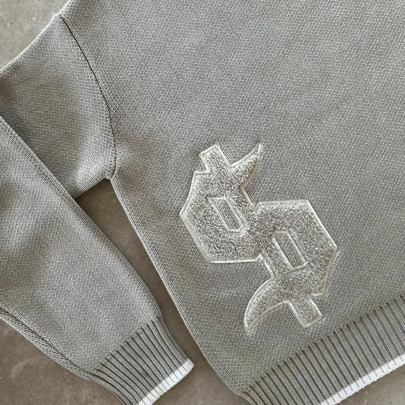Grey loose-fit long sleeve acetate Jacquard knit pullover coat on a hanger.