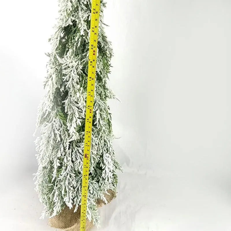 Small 24-inch artificial Christmas tree with lights and snow finish on desktop