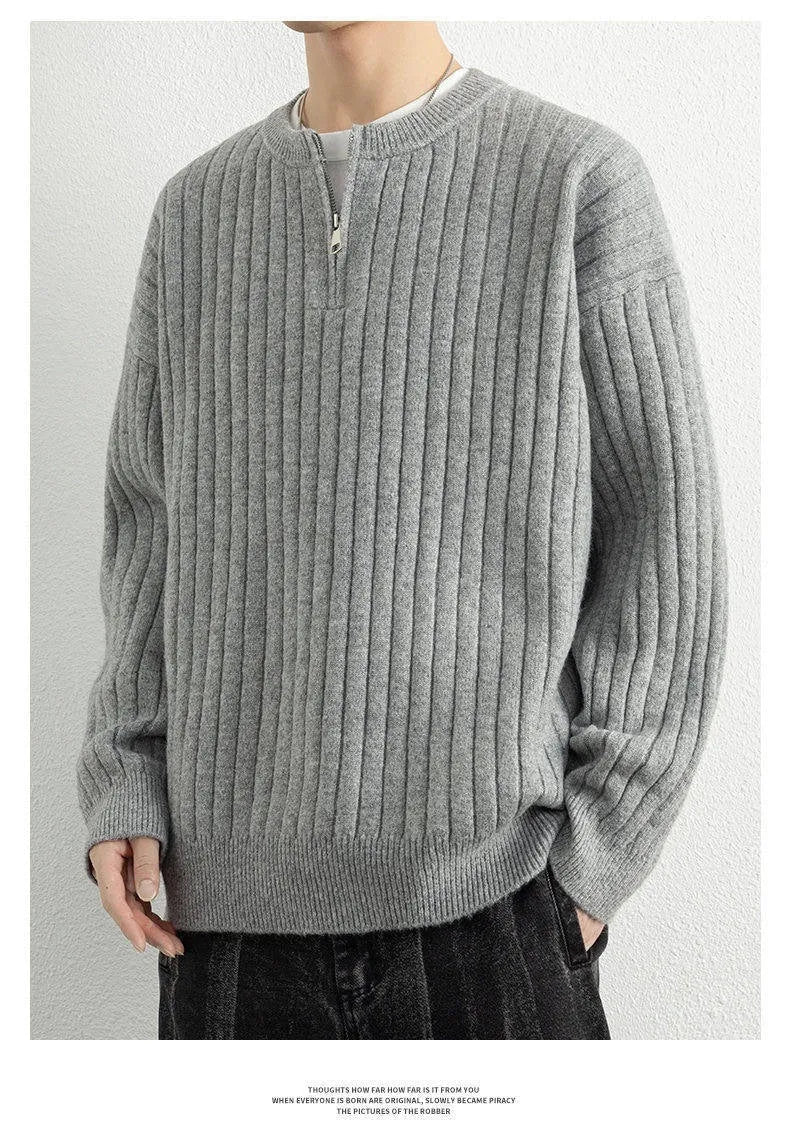 A grey men's half-zip texture knit sweater with a loose fit and long sleeves on a hanger.