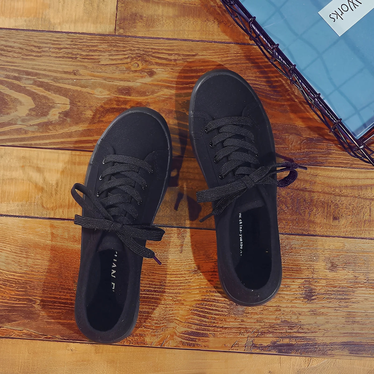All black canvas low-top lace-up flat shoes for women on a white background