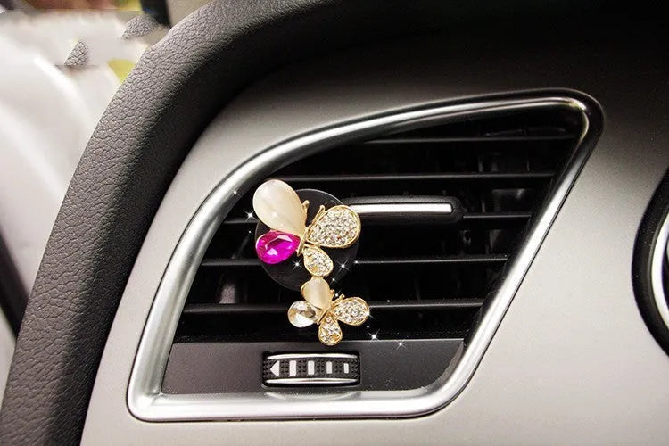 Alloy car fragrance clip with decorative charm attached to car air vent