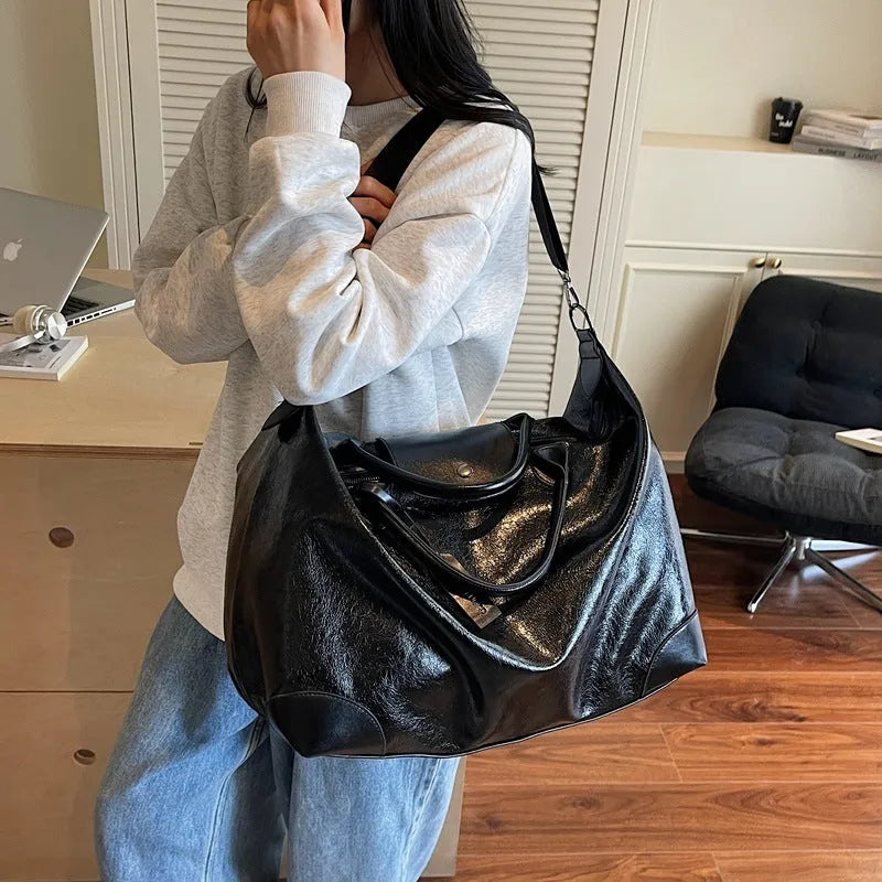 Women's large capacity hand-carry travel bag in black or silver with 36-55 litre capacity